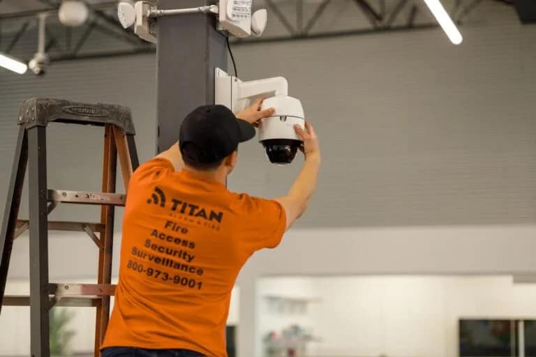 Titan Alarm & Fire technician servicing a PTZ security camera